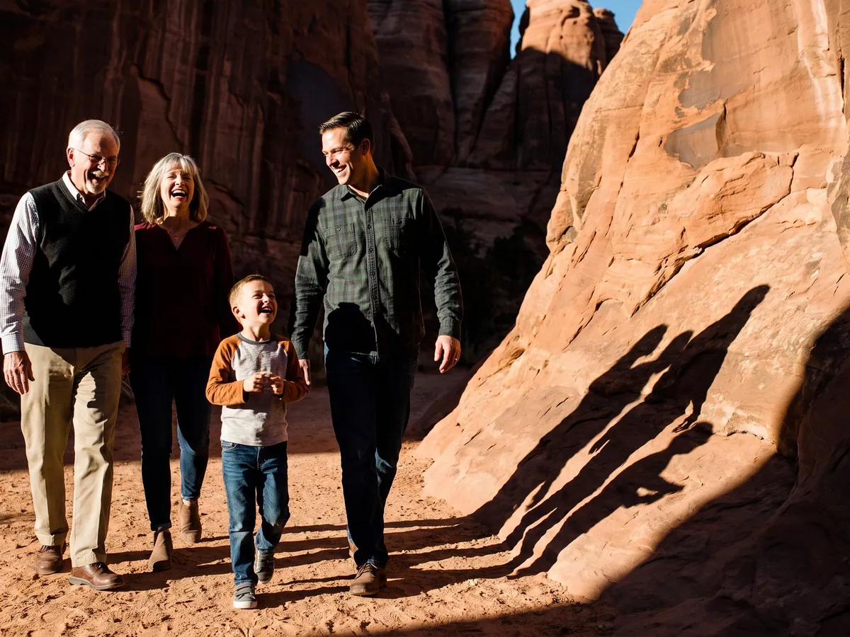 A family of five laughing on a desert trail