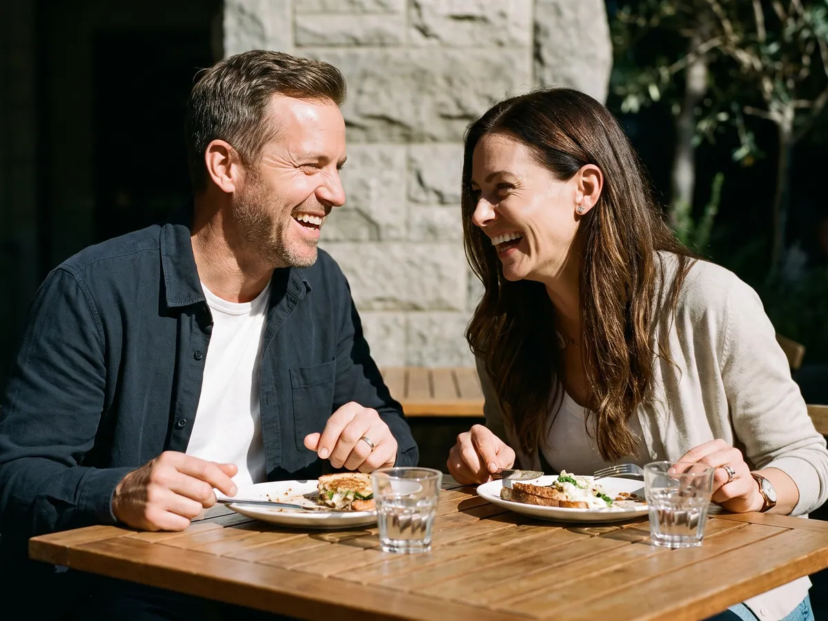 A couple laughing over lunch at an outdoor cafe