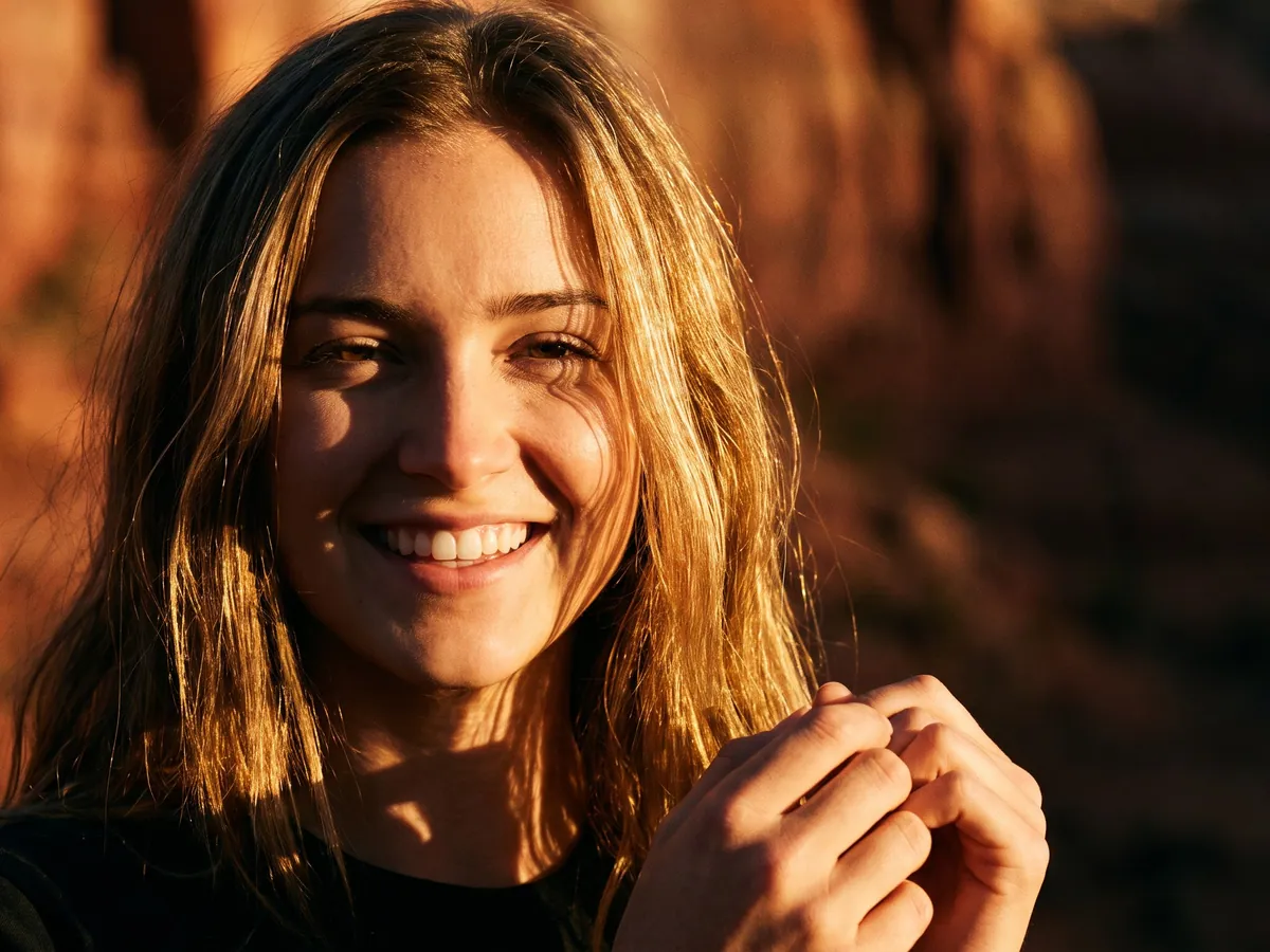 A young woman with a bright smile at golden hour
